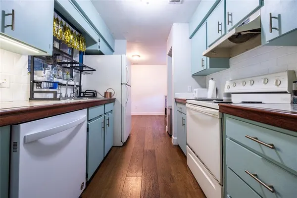 a kitchen with stainless steel appliances granite countertop a sink a stove and a wooden floors