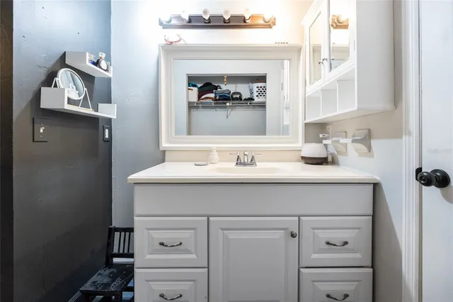 a bathroom with a sink vanity and a mirror