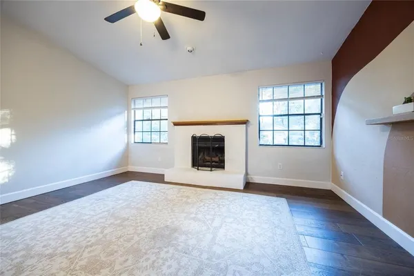 an empty room with windows and fireplace