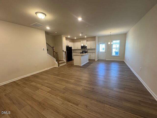 448 Glen Clova Drive Raleigh, NC 27603 - Photo 4 of 23 an empty room with wooden floor and windows