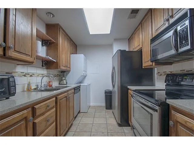 a kitchen with stainless steel appliances granite countertop a refrigerator stove and sink