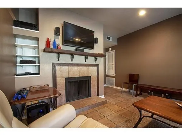a living room with furniture a flat screen tv and a fireplace