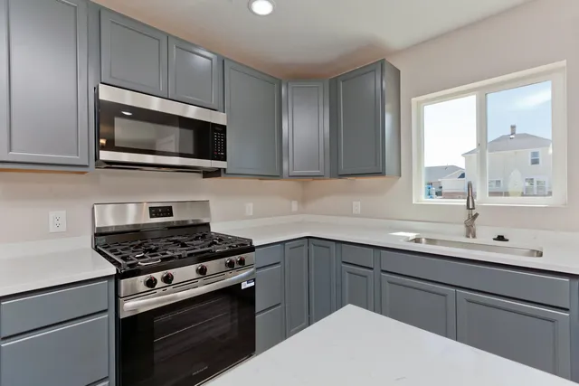 a kitchen with cabinets stainless steel appliances and a sink