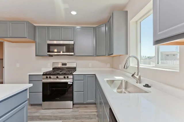 a kitchen with stainless steel appliances a stove a sink a microwave and cabinets