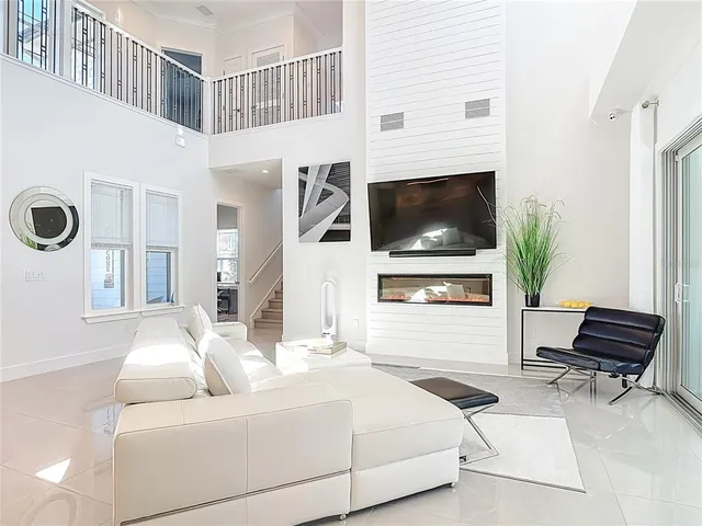 a living room with furniture kitchen view and a large window