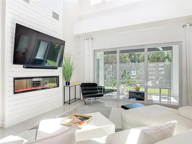 a living room with stainless steel appliances kitchen island furniture and a flat screen tv