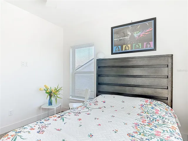 a bedroom with a bed and large windows
