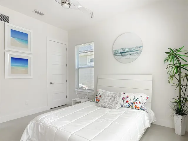 a bedroom with a bed and a flat tv screen next to a window