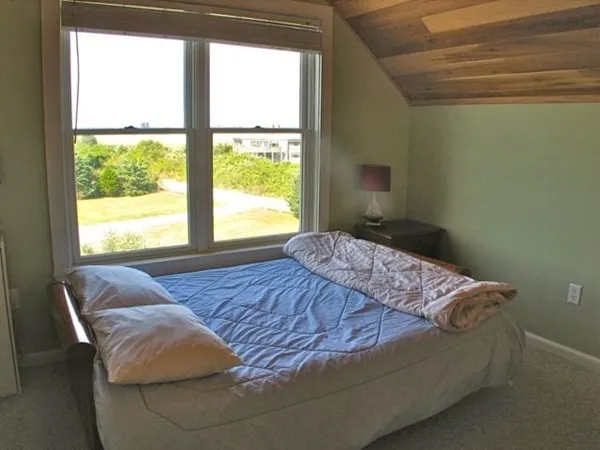 a bed sitting in a bedroom next to a window