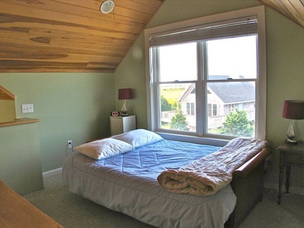 76 Mattakesett Way Edgartown, MA 02539 - Photo 13 of 28 a bed sitting in a bedroom next to a window
