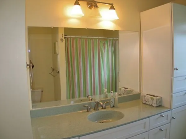 a bathroom with a granite countertop sink and a window