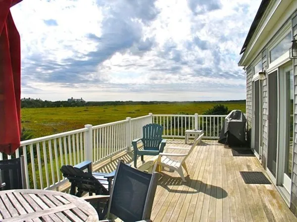 a view of a balcony with chair and wooden floor