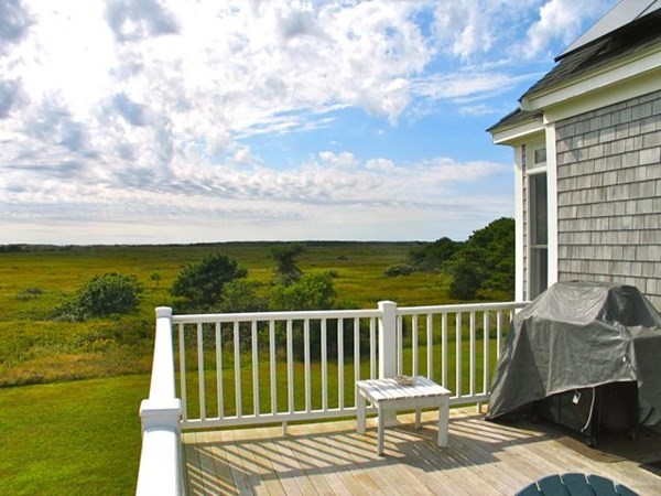 76 Mattakesett Way Edgartown, MA 02539 - Photo 23 of 28 a view of a balcony with chair and wooden floor