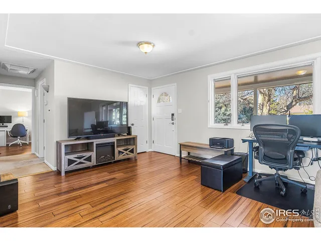 a living room with furniture flat screen tv and large window