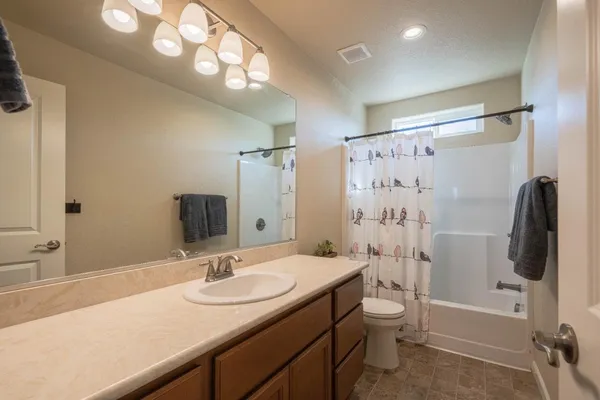 a bathroom with a granite countertop sink toilet and shower