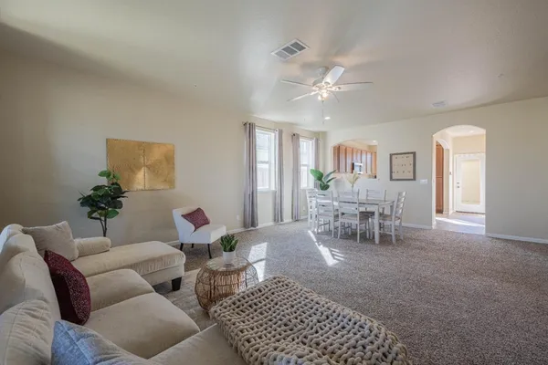 a living room with furniture a dining table and with chandelier