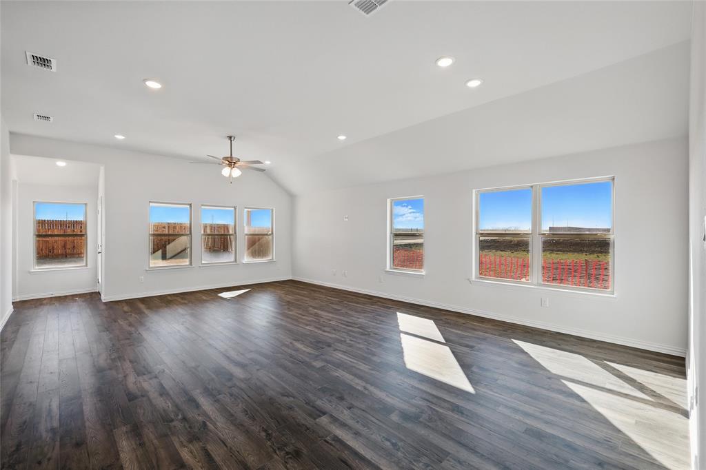 2529 Rivers W Road Anna, TX 75409 - Photo 8 of 22 Unfurnished living room with lofted ceiling, dark wood finished floors, healthy amount of natural light, recessed lighting, and ceiling fan