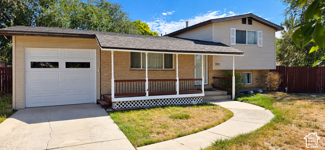 2989 Rae Street West Valley City, UT 84120 - Photo 2 of 25 Brick and siding exterior with a covered porch featuring white columns and dark-stained railings