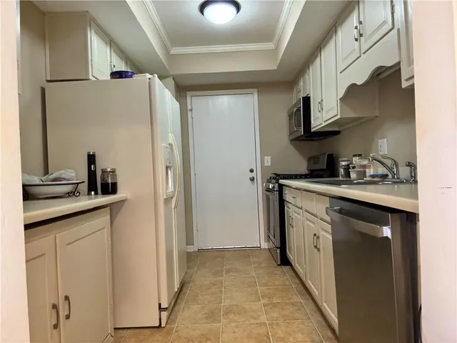 a kitchen with stainless steel appliances granite countertop a sink and a refrigerator