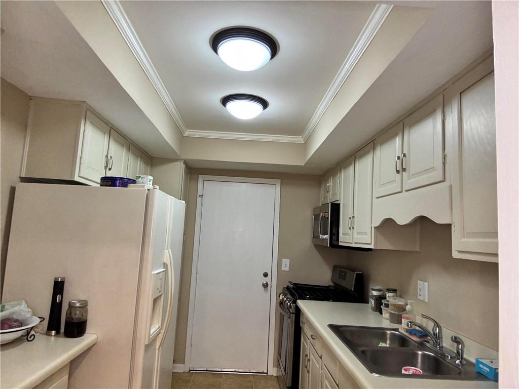 6851 Roswell Road, Unit O24 Sandy Springs, GA 30328 - Photo 6 of 10 a kitchen with stainless steel appliances granite countertop a sink stove and refrigerator