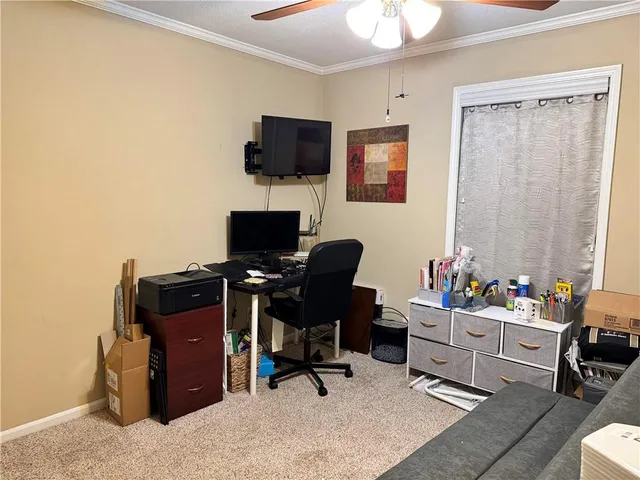 a view of a workspace with furniture and a window
