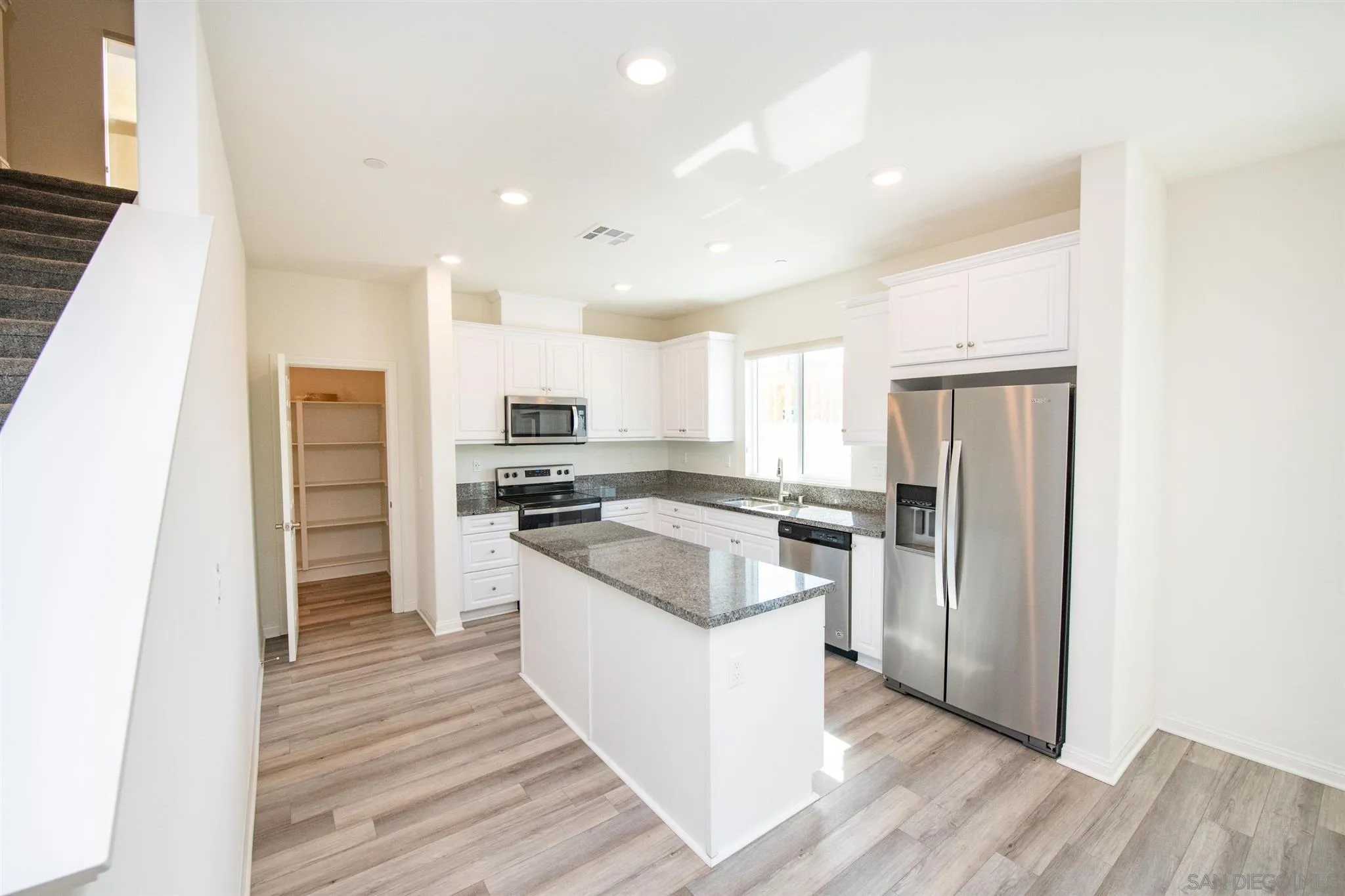 10711 Porter Terrace Spring Valley, CA 91978 - Photo 5 of 17 a kitchen with a refrigerator a stove top oven and kitchen island