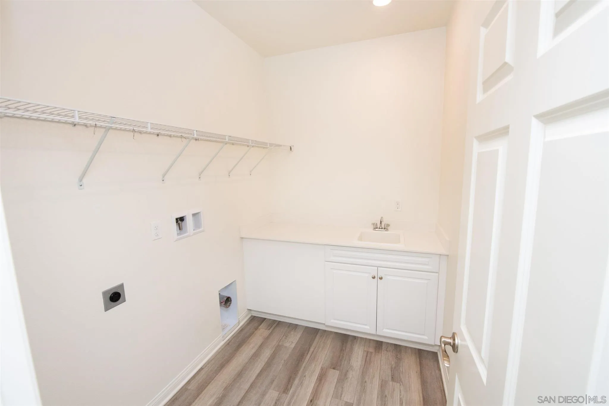10711 Porter Terrace Spring Valley, CA 91978 - Photo 8 of 17 a view of a kitchen with white cabinets and wooden floor