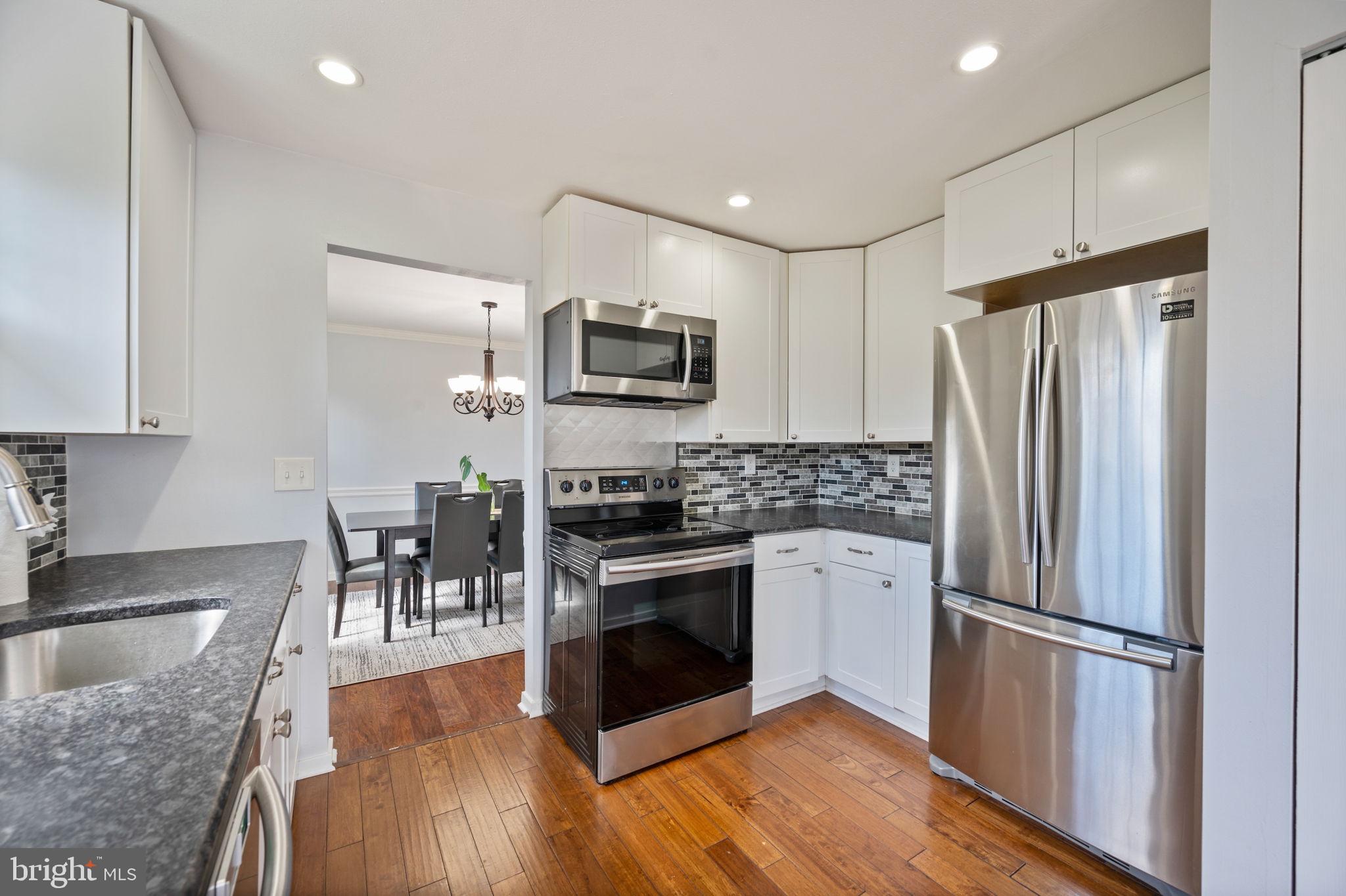 645 Ridgefield Court Glen Burnie, MD 21061 - Photo 2 of 62 a kitchen with granite countertop a refrigerator and a stove top oven