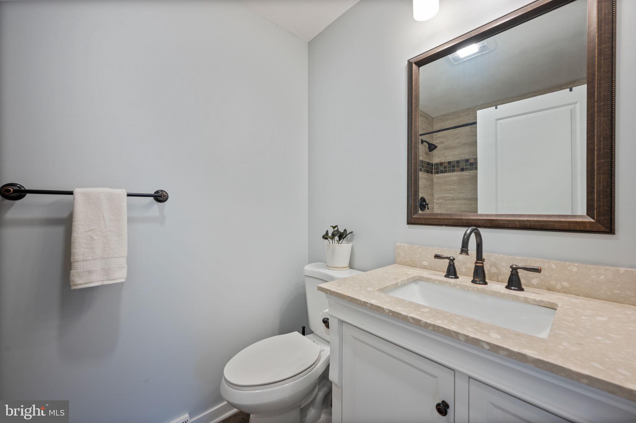645 Ridgefield Court Glen Burnie, MD 21061 - Photo 33 of 62 a bathroom with a granite countertop toilet sink and mirror