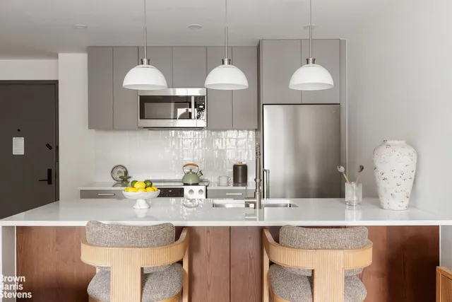 a kitchen with a sink a stove and chairs