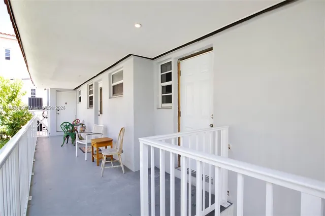 a view of a hallway with wooden floor and stairs