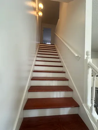 a spacious bathroom with a granite countertop sink a toilet a mirror and shower