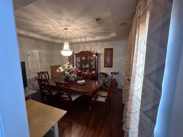 a view of a dining room with furniture and a chandelier