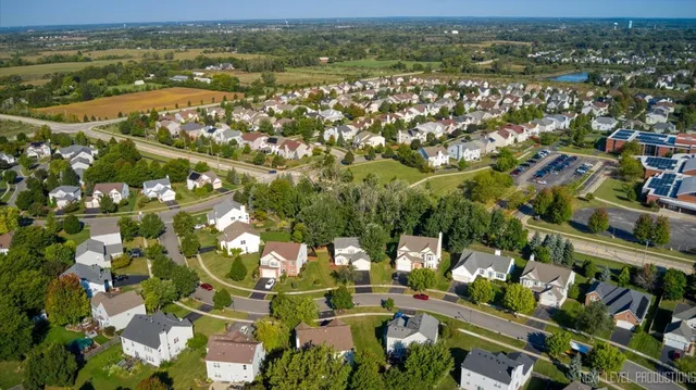 an aerial view of residential houses with outdoor space and trees