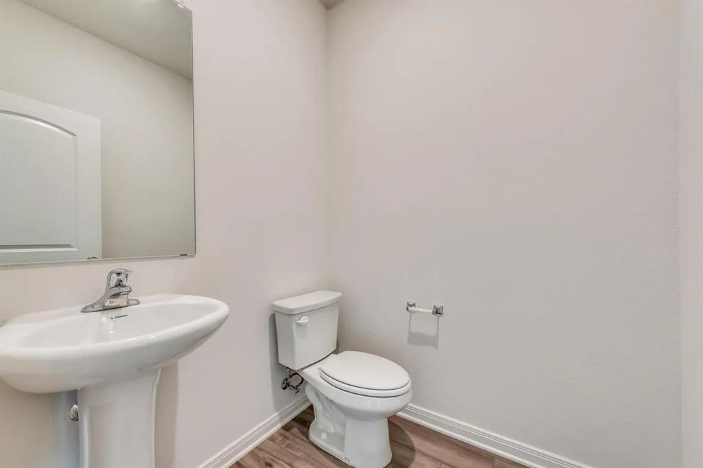912 Mallorie Lane Ferris, TX 75125 - Photo 20 of 24 Bathroom featuring baseboards and wood finished floors