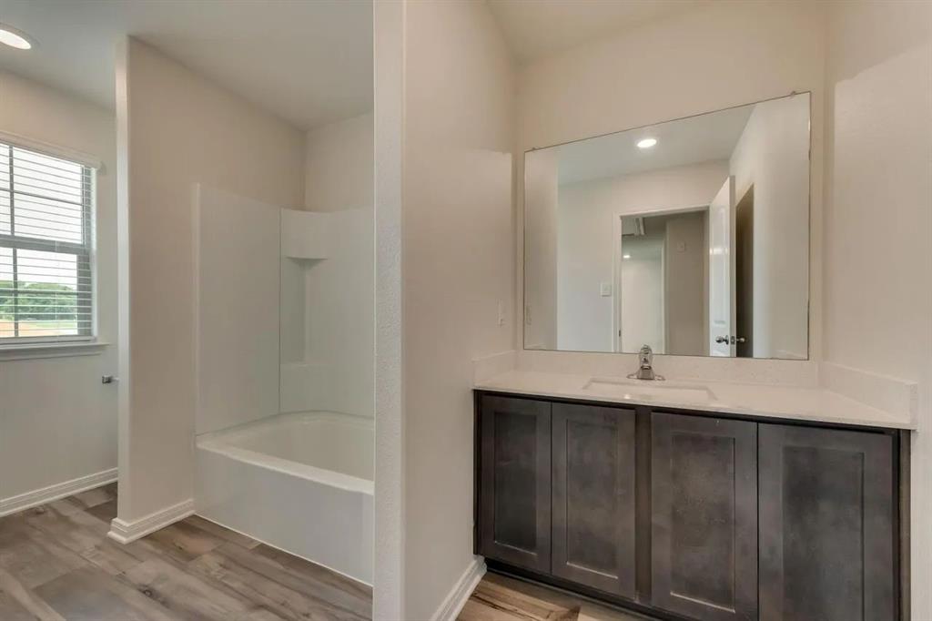 912 Mallorie Lane Ferris, TX 75125 - Photo 22 of 24 Bathroom featuring recessed lighting, vanity, light wood-style floors, and washtub / shower combination