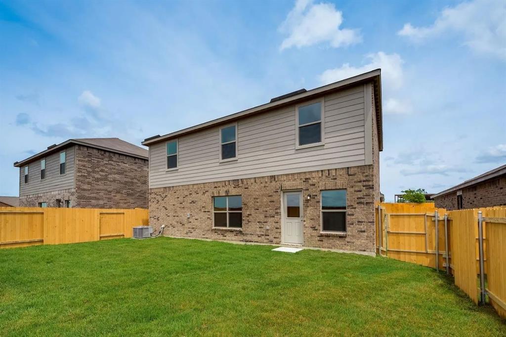 912 Mallorie Lane Ferris, TX 75125 - Photo 24 of 24 Rear view of house featuring a fenced backyard and brick siding