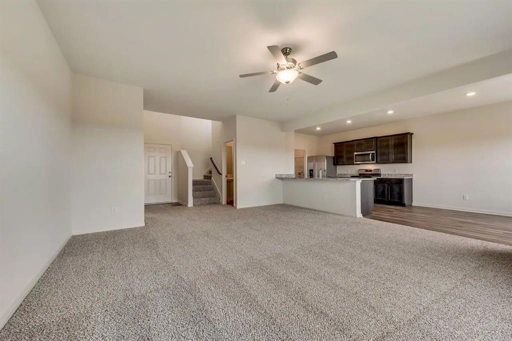 912 Mallorie Lane Ferris, TX 75125 - Photo 6 of 24 Unfurnished living room featuring dark carpet, stairway, ceiling fan, and recessed lighting