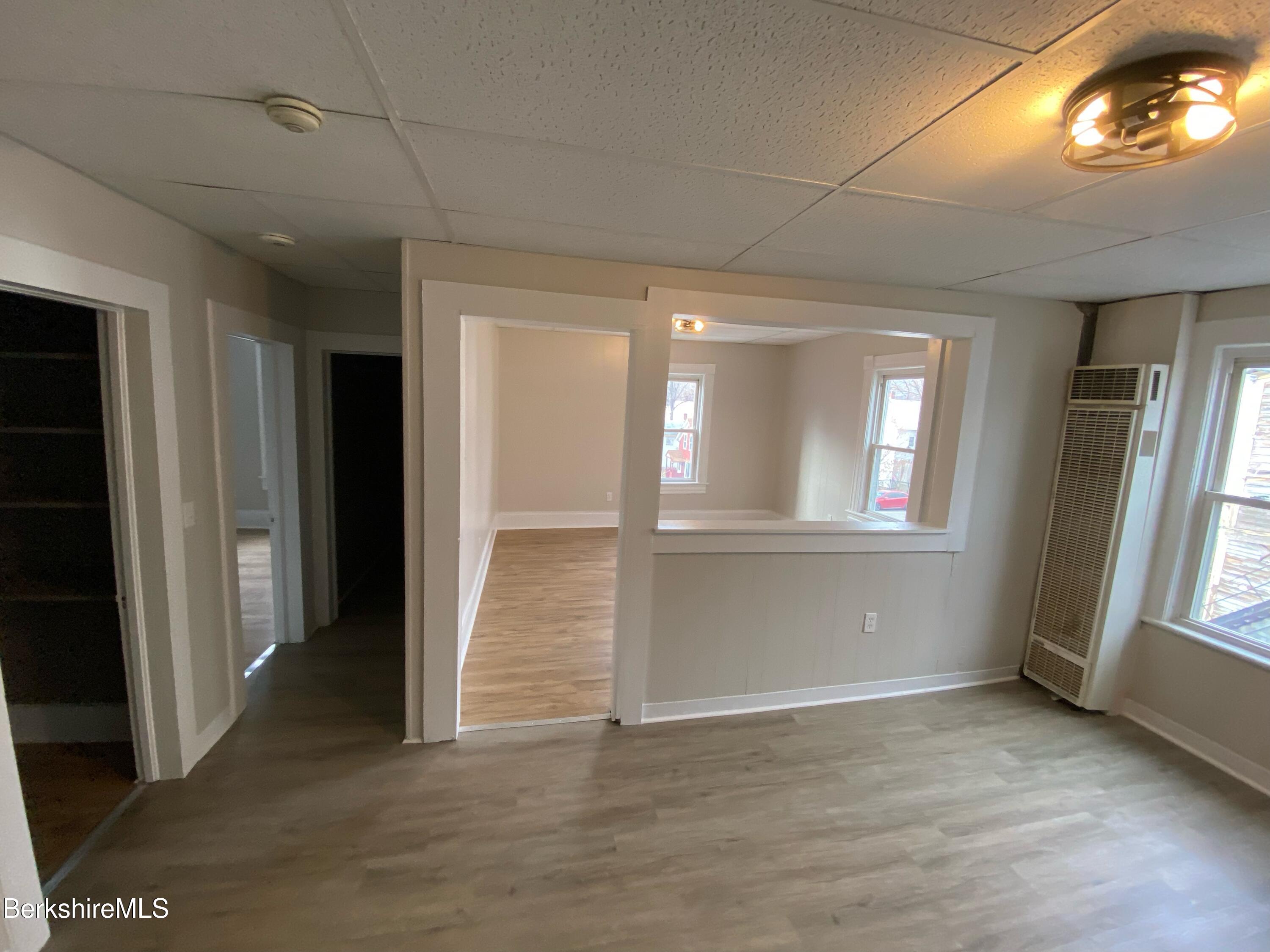 88 Summer Street, Unit 2C Adams, MA 01220 - Photo 4 of 10 an empty room with wooden floor and windows
