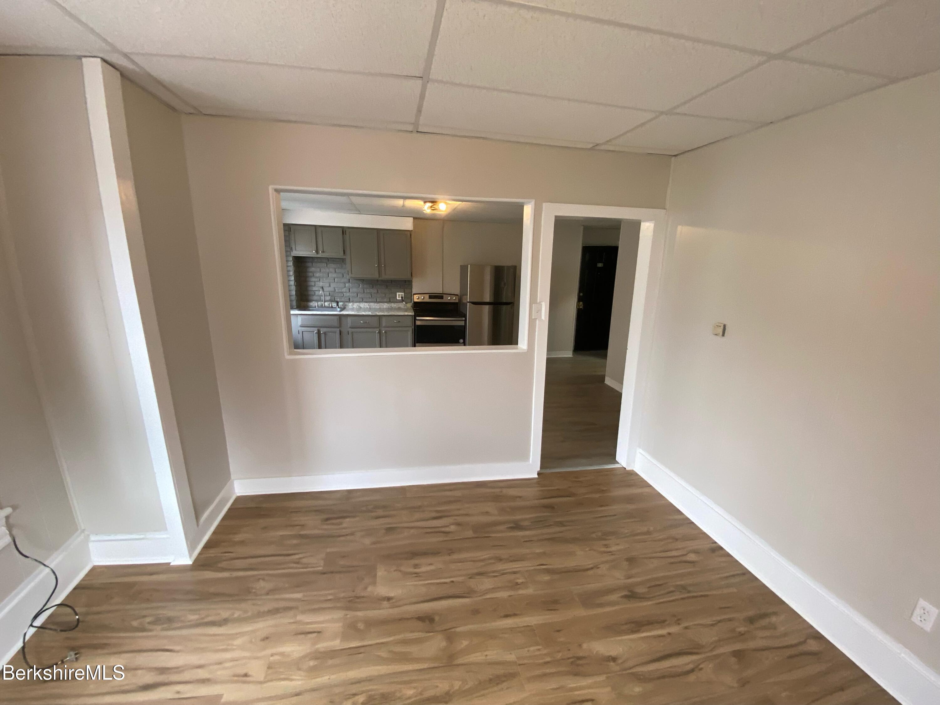 88 Summer Street, Unit 2C Adams, MA 01220 - Photo 6 of 10 an empty room with wooden floor and windows