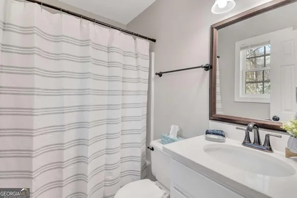 a bathroom with a sink a toilet and shower curtain