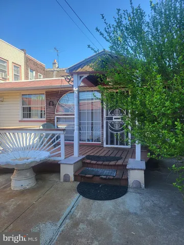a view of a backyard with table and chairs potted plants and a large tree
