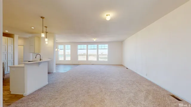 a view of an empty room with a kitchen