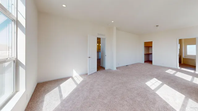 a bedroom with a bed and a large window