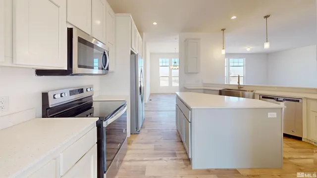 a kitchen with stainless steel appliances granite countertop a sink a stove and a refrigerator