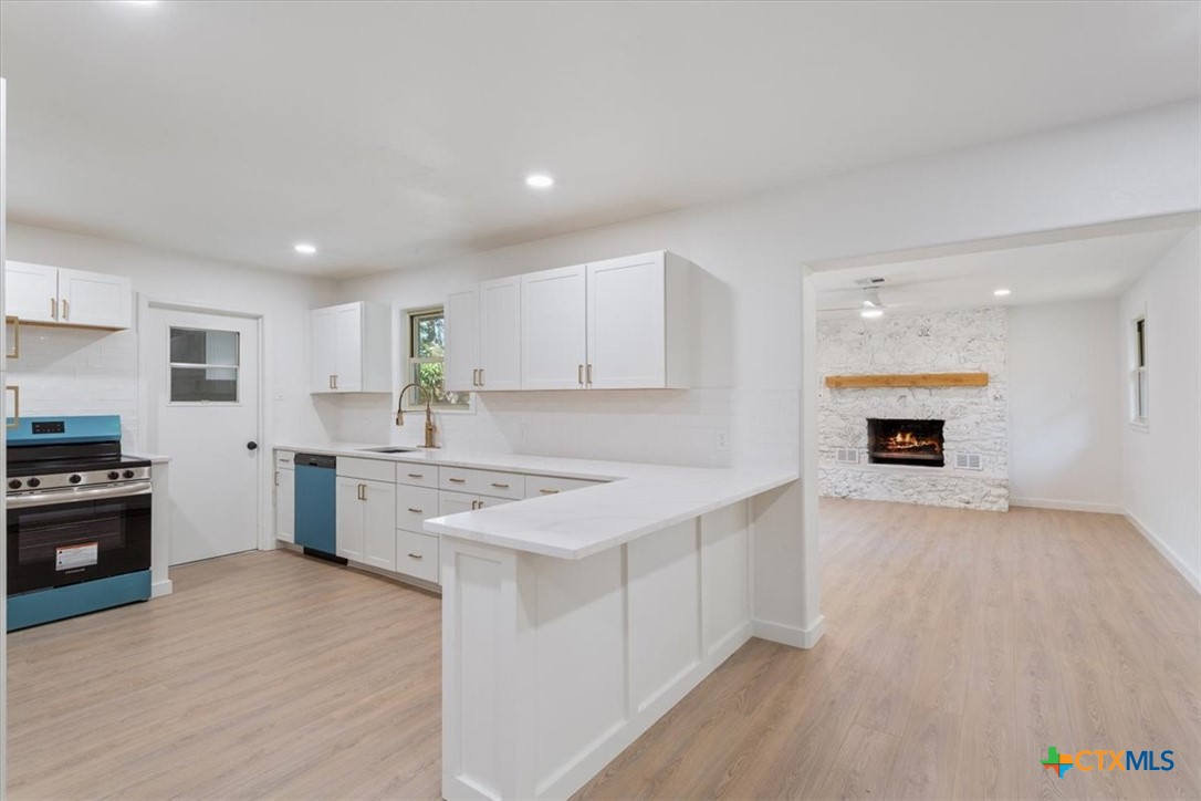 4412 Briar Cliff Road Temple, TX 76502 - Photo 12 of 35 a kitchen with a sink dishwasher a stove and a refrigerator with wooden floor