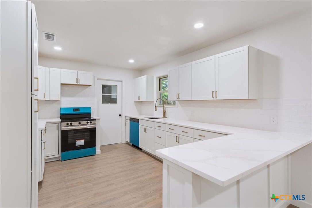 4412 Briar Cliff Road Temple, TX 76502 - Photo 15 of 35 a kitchen with white cabinets and stainless steel appliances