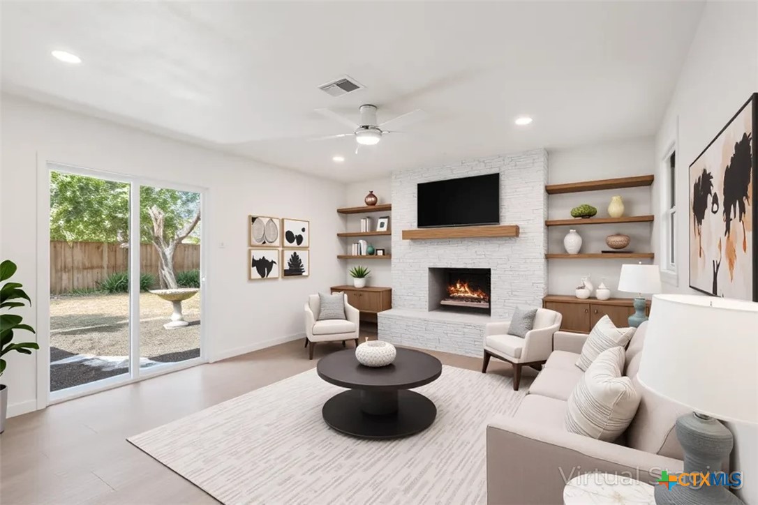 4412 Briar Cliff Road Temple, TX 76502 - Photo 18 of 35 a living room with furniture a flat screen tv and a fireplace