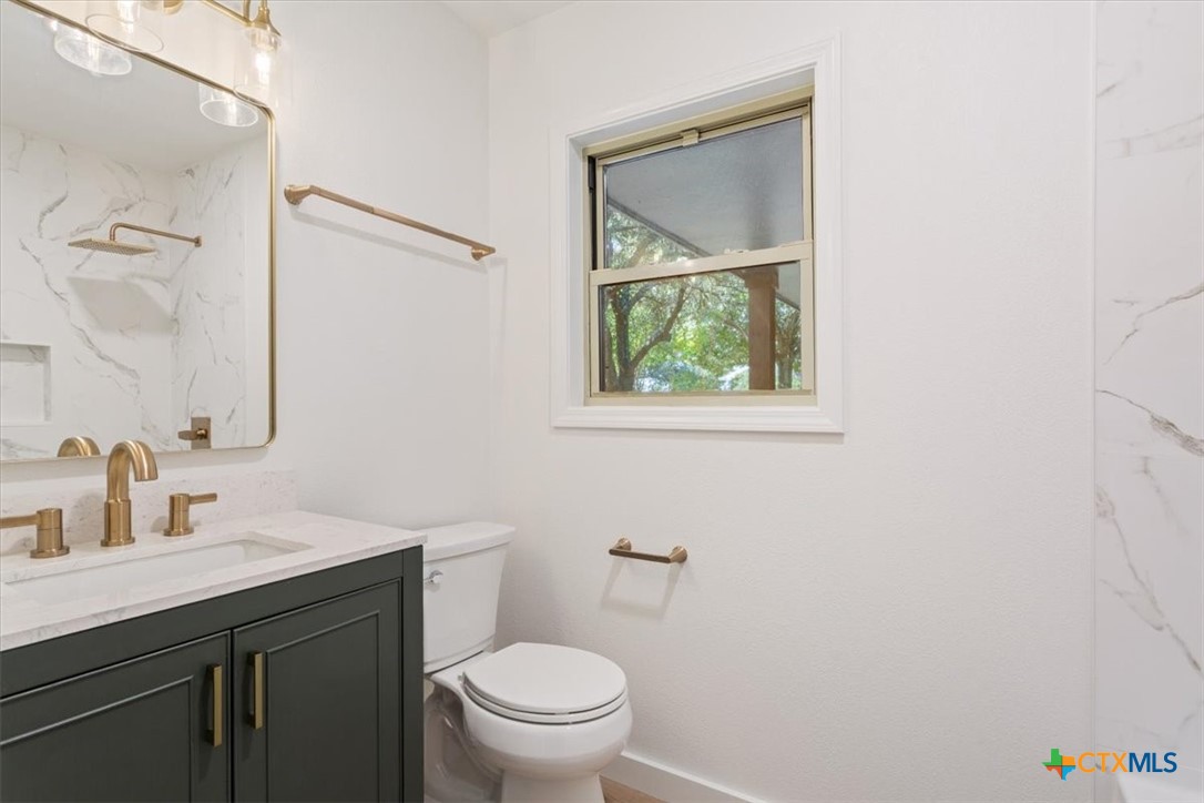 4412 Briar Cliff Road Temple, TX 76502 - Photo 30 of 35 a bathroom with a toilet sink vanity and mirror