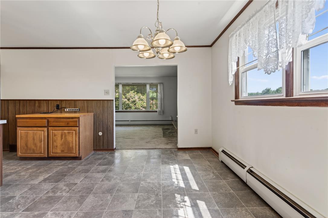 62 Stoney Road Tamaqua, PA 18252 - Photo 23 of 61 A classic chandelier illuminates the dining area, featuring durable tile flooring and natural light.